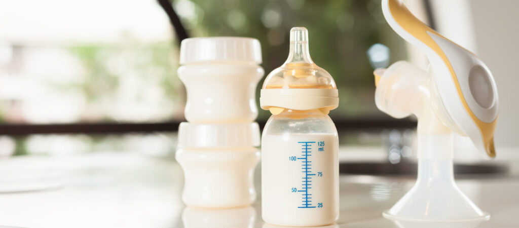 Baby bottle with milk and manual breast pump