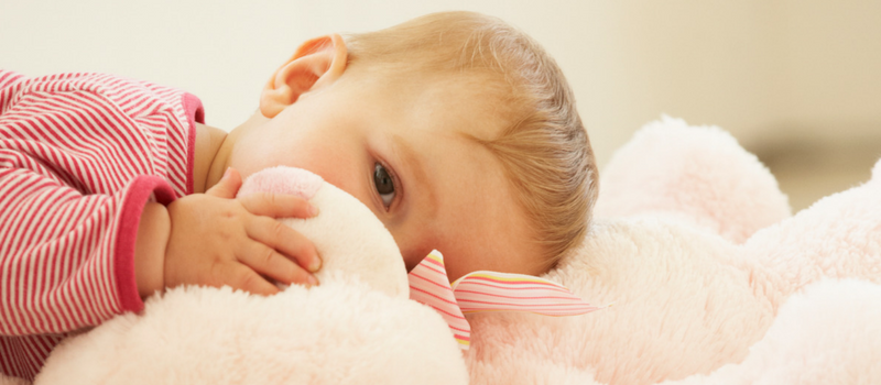 a baby laying on a stuffed animal