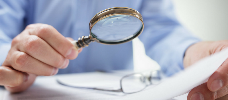 a hand holding a magnifying glass