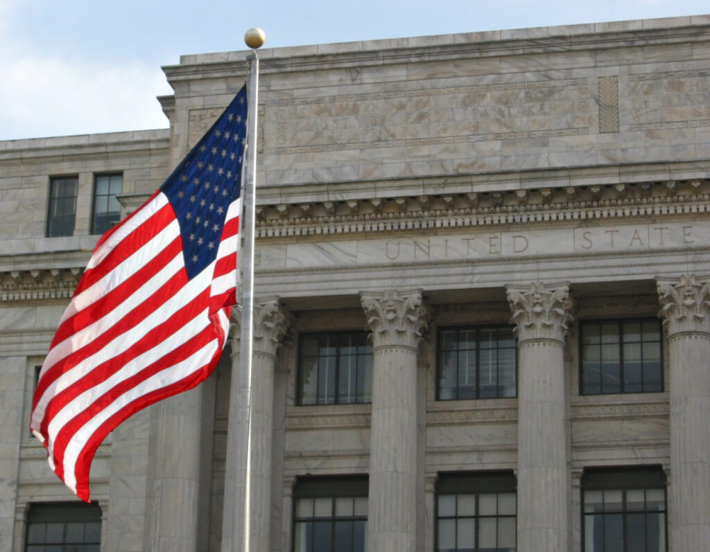 us flag waving in the wind outside a building