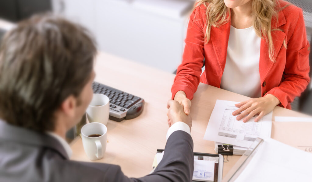 a man and woman shaking hands across a table