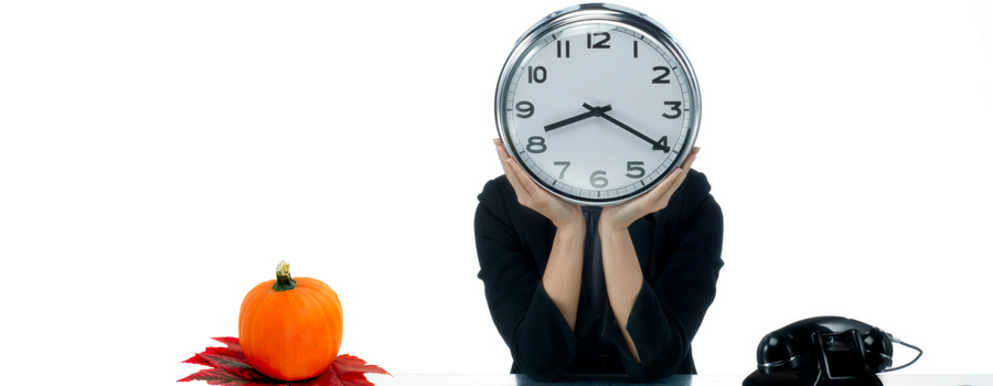 a person with a clock in front of their face with a pumpking and telephone on each side